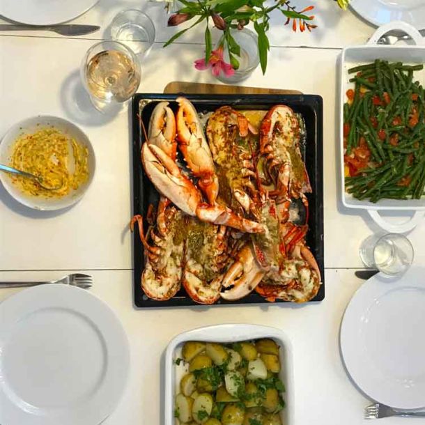 Tomhara - top view of dining table with home-cooked lobster in serving dish.